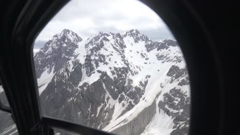 view in the helicopter from the passenger's seat to outside seeing the snow mountain