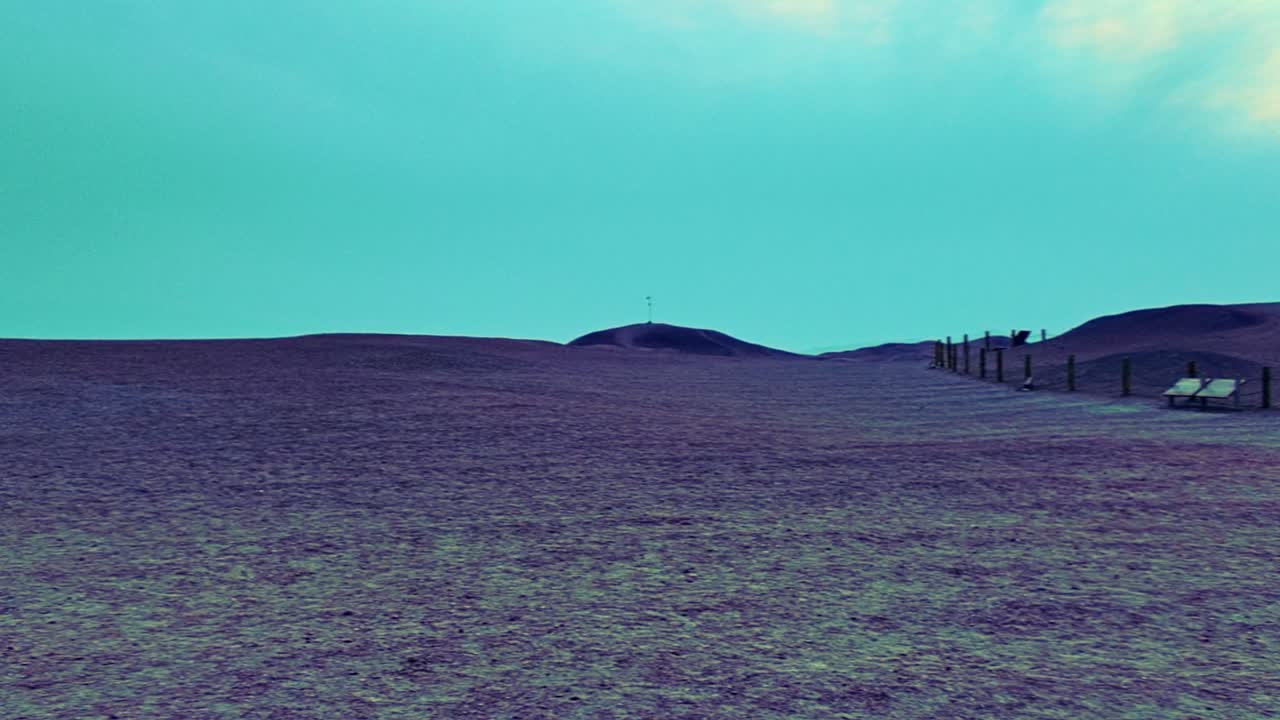Yangguan Pass, Dunhuang, Gansu Province, China - A Weathered Earthen Ruin Rises from Rolling Desert Hills, Framed by Open Plains and a Softly Colored Sky - Pan Right Shot