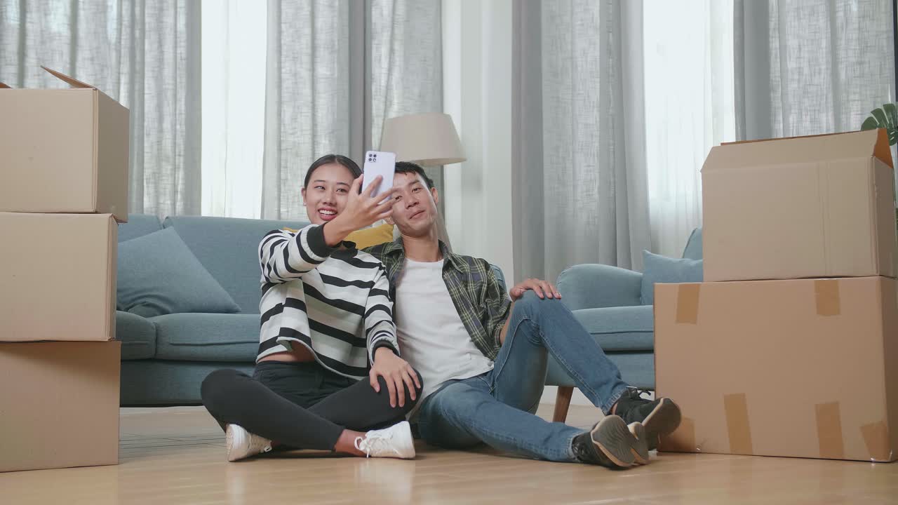 집 을 옮기는 동안 셀피 를 찍는 부부