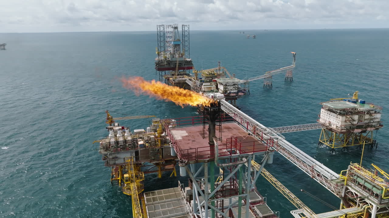 Aerial close-up of gas flare on offshore processing platform, oil industry