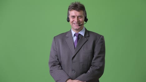 mature handsome businessman against green background