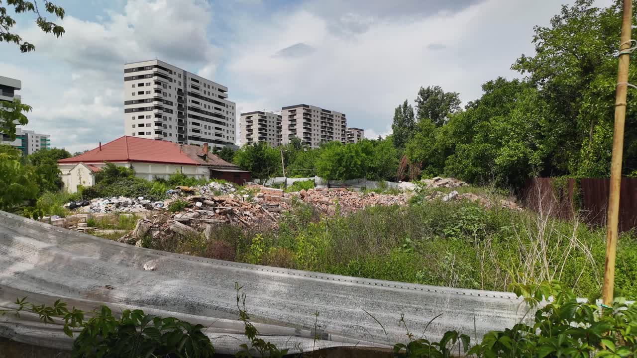 Tatarasi Solumania in Iasi features apartment blocks behind a debris-filled construction site with overgrown greenery