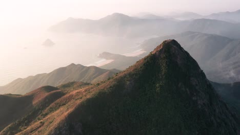 órbita aérea em torno do pico pontiagudo sai kung hong kong, névoa cerca a baía de ondas grandes