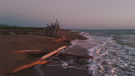 wooden tipi by the sea at a natural beach during sunset