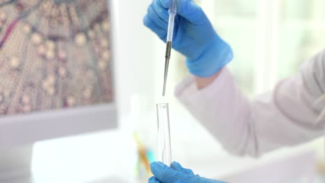 scientist working in a laboratory with pipette and microscope display