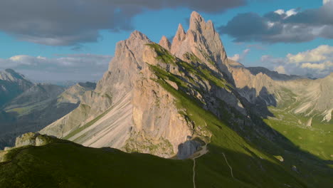 Vibrant-majestic-South-Tyrol-peak-rural-green-mountain-pasture-slope-aerial-view