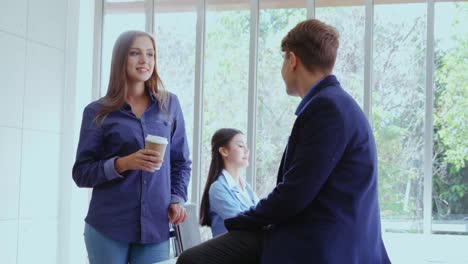 mujer de negocios feliz y hombre de negocios teniendo una conversación en una oficina moderna.