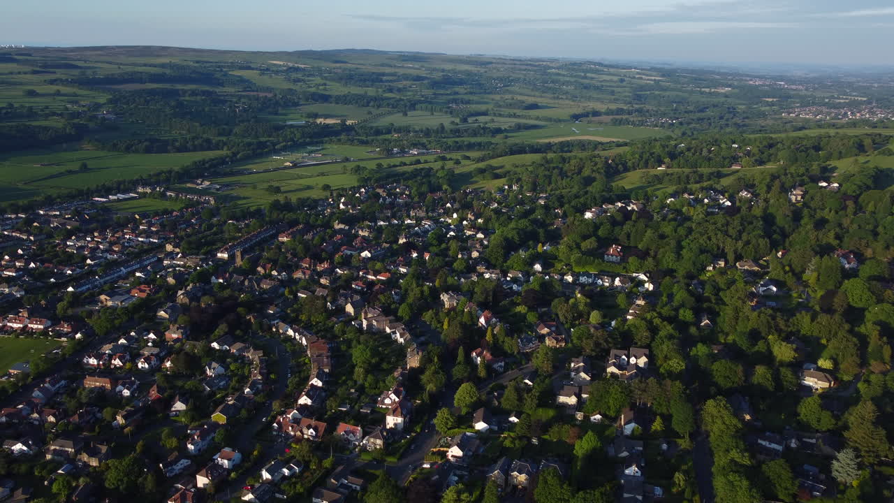 establecimiento de drones disparados sobre casas unifamiliares y semi-unifamiliares en la ciudad rural de ilkley con árboles en la hora dorada de west yorkshire, reino unido