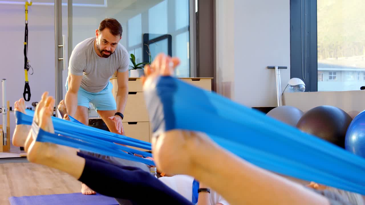 entrenador ayudando a las mujeres mayores en la realización de yoga 4k