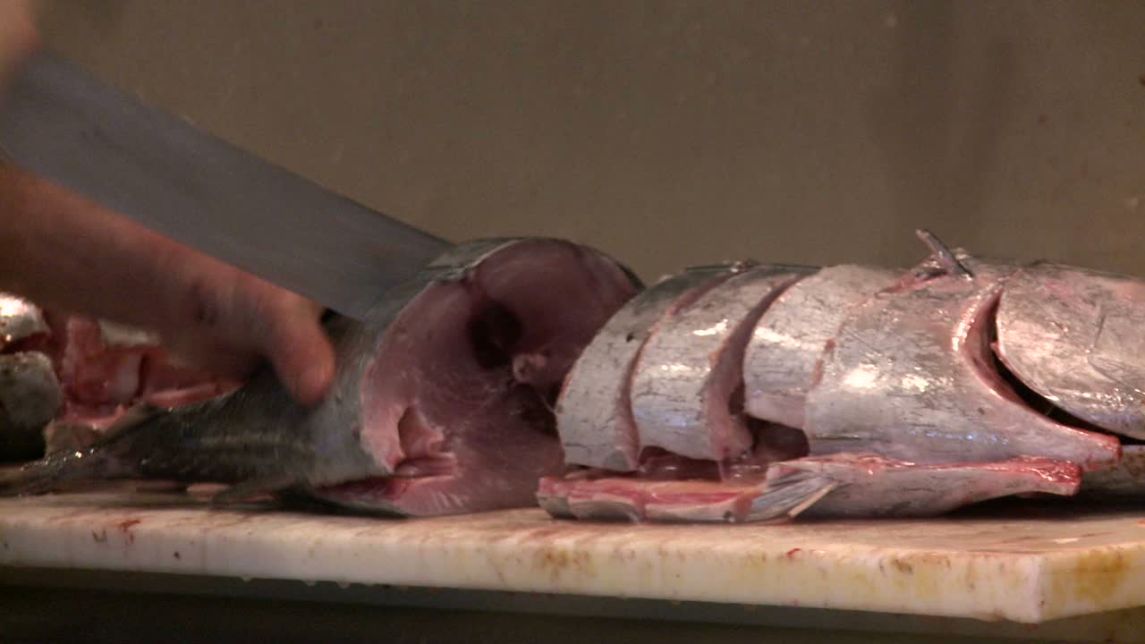 정육점은 시장에서 신선한 생선을 자른다