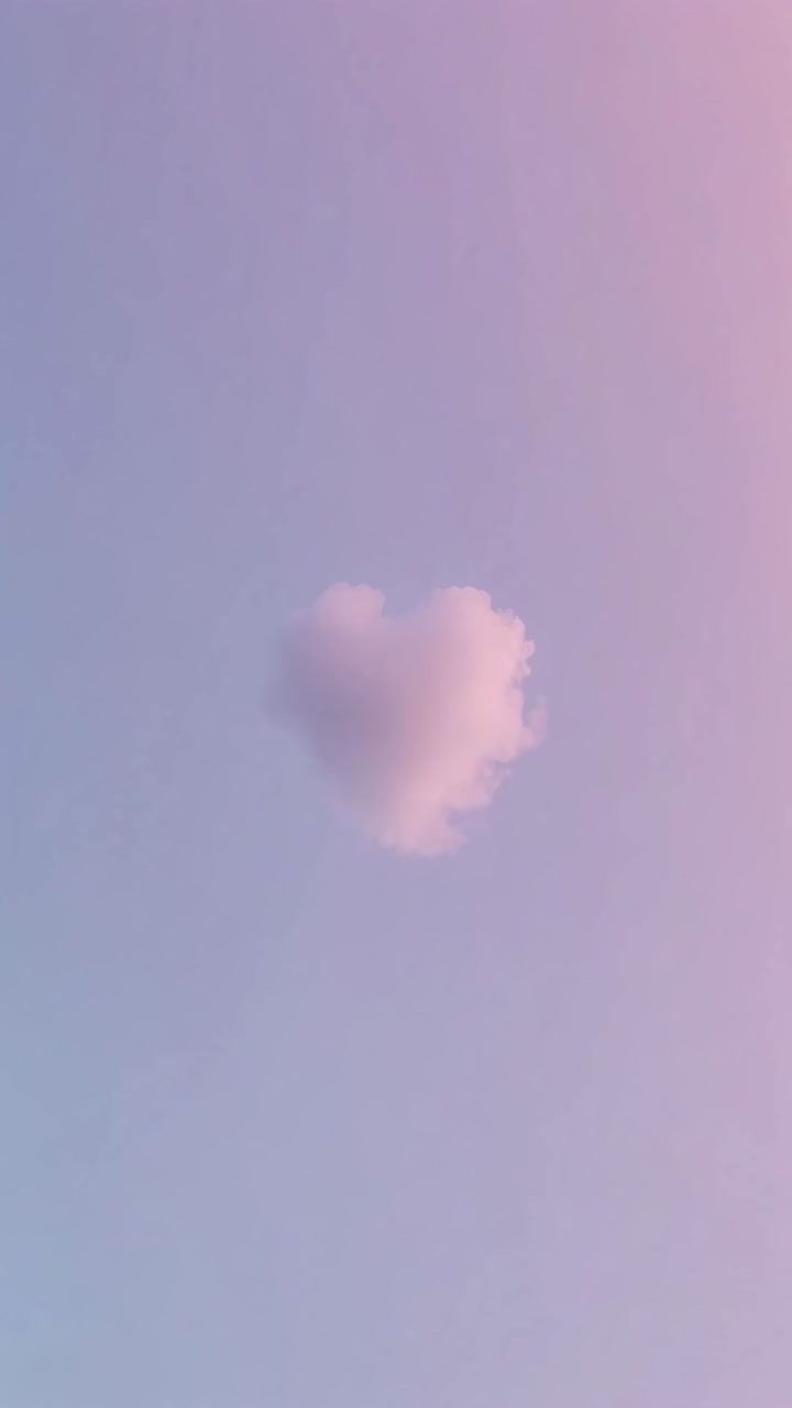 A heart-shaped cloud against a pastel pink and blue sky, captured from a low angle