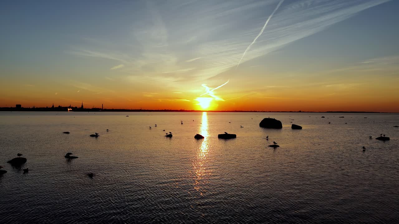 해가 뜨고 스카이라인 드론이 바다 위를 날아다니며 하늘의 스카이 라인이 빛나고, 바위가 조용한 물 속에 떠다니며, 공중에서 볼 수 있습니다.