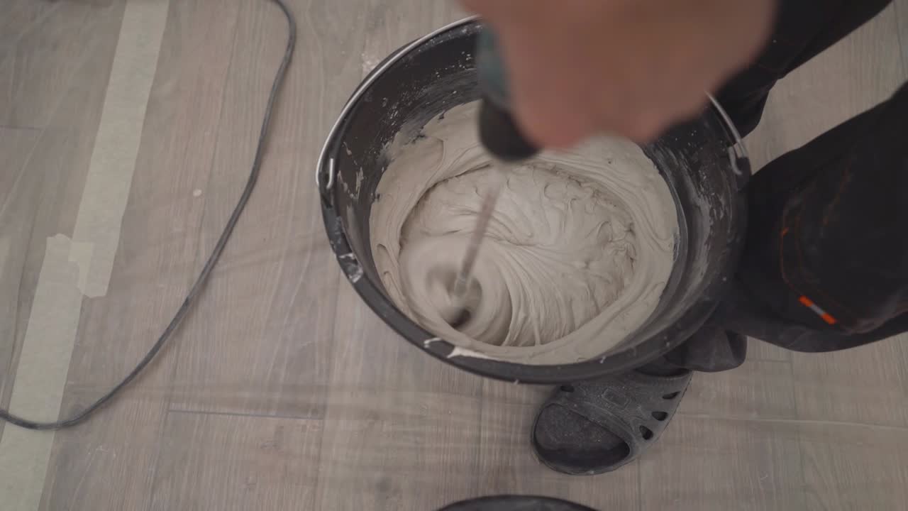 Secchio con stucco denso. Stucco acrilico bianco per vetri mescolato in un secchio. Consistenza densa. Un secchio da costruzione riempito con malta bianca densa.
