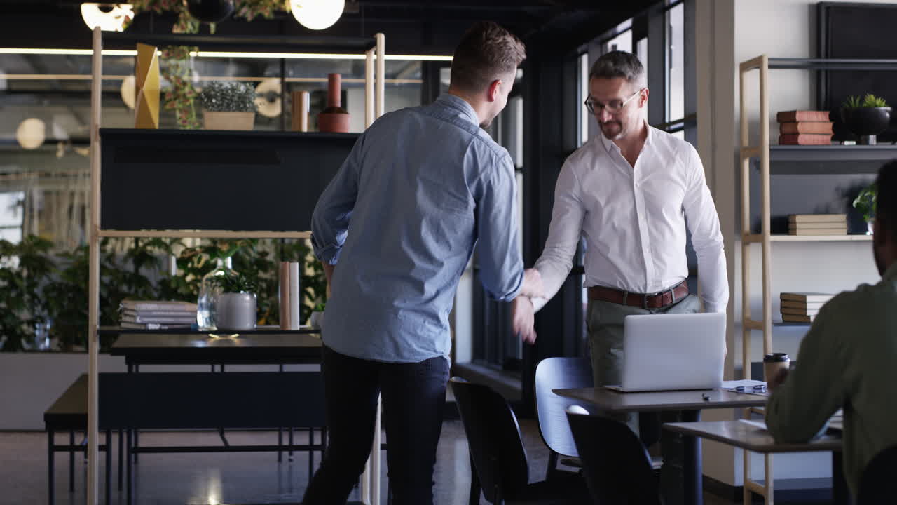 현대 사무실에서 악수하는 두 사업가