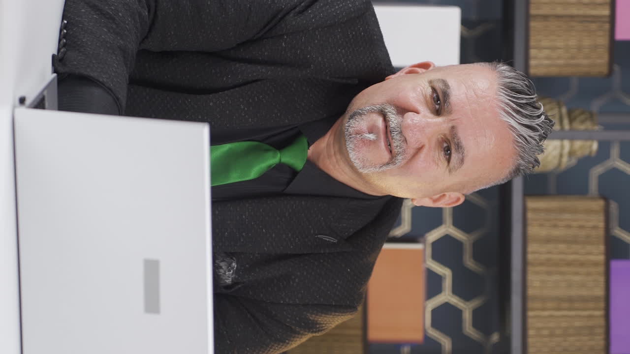 카메라를 통해 페이스타임을 말하는 사업가의 수직 비디오.