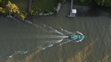 Draufsicht-Auf-Ein-Sammelbusboot,-Das-In-Der-Nähe-Von-Docks-Bei-Sonnenuntergang-Am-Parana-Fluss,-Deltagebiet,-Argentinien,-Segelt