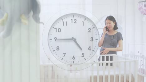 clock with fast moving hands over happy pregnant asian woman by cot talking on phone