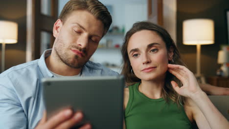 Pareja-Molesta-Hablando-De-Llamada-De-Pestaña-En-El-Primer-Plano-De-La-Sala-De-Estar.-Pad-De-Videollamadas-De-Pareja-Triste