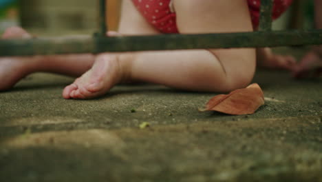 Baby-girl's-hands-and-feet-crawling-on-concrete