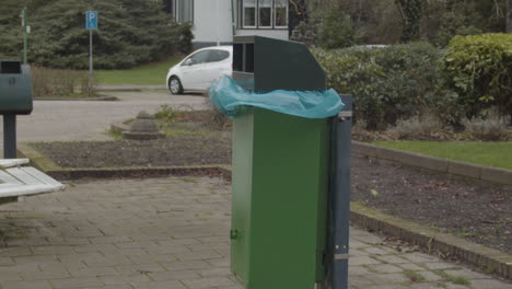 bolsa de basura de plástico en papelera verde aleteando en el viento - cámara lenta