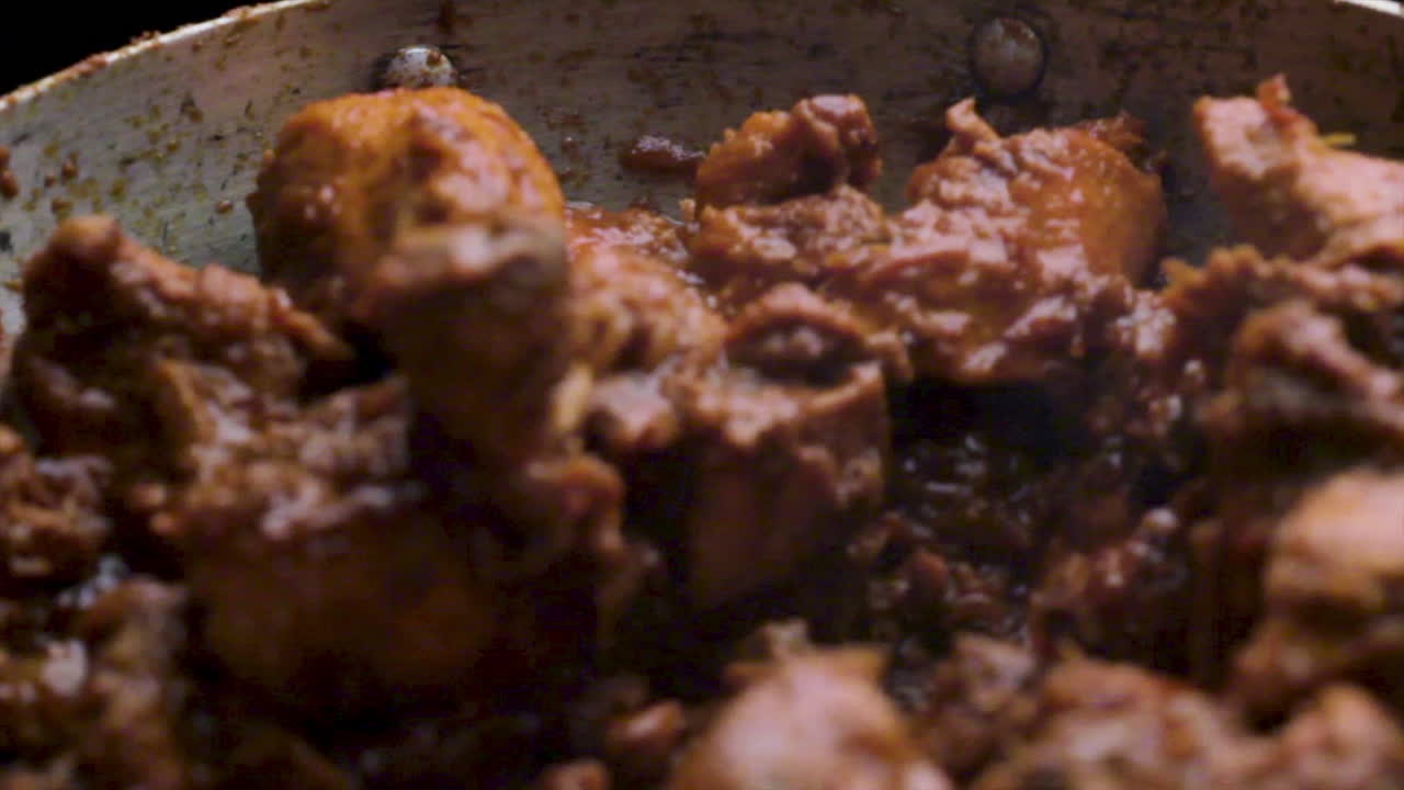 receta casera de pollo picante al estilo indio cocinada en una sartén por el chef, revolviendo el curry de pollo y cocinando la receta de pollo, cocinando comida no vegetariana