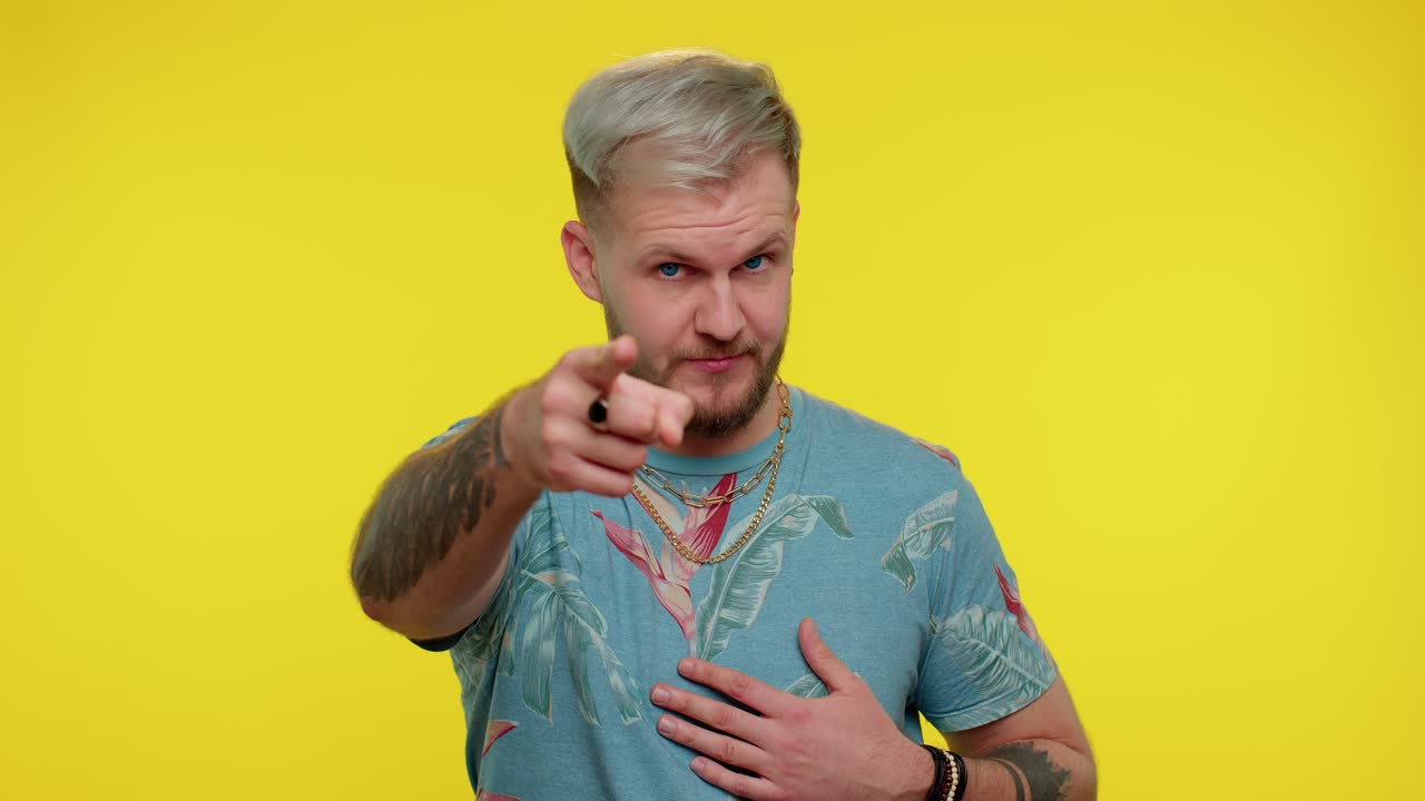 hombre adulto guapo apuntando a la cámara y mirando con expresión alegre y lúdica, haciendo una elección