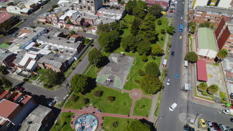 Neighborhood-Park-With-Lush-Green-Foliage-and-Basketball-Court-with-People-Playing-Basketball-During-Sunny-Day