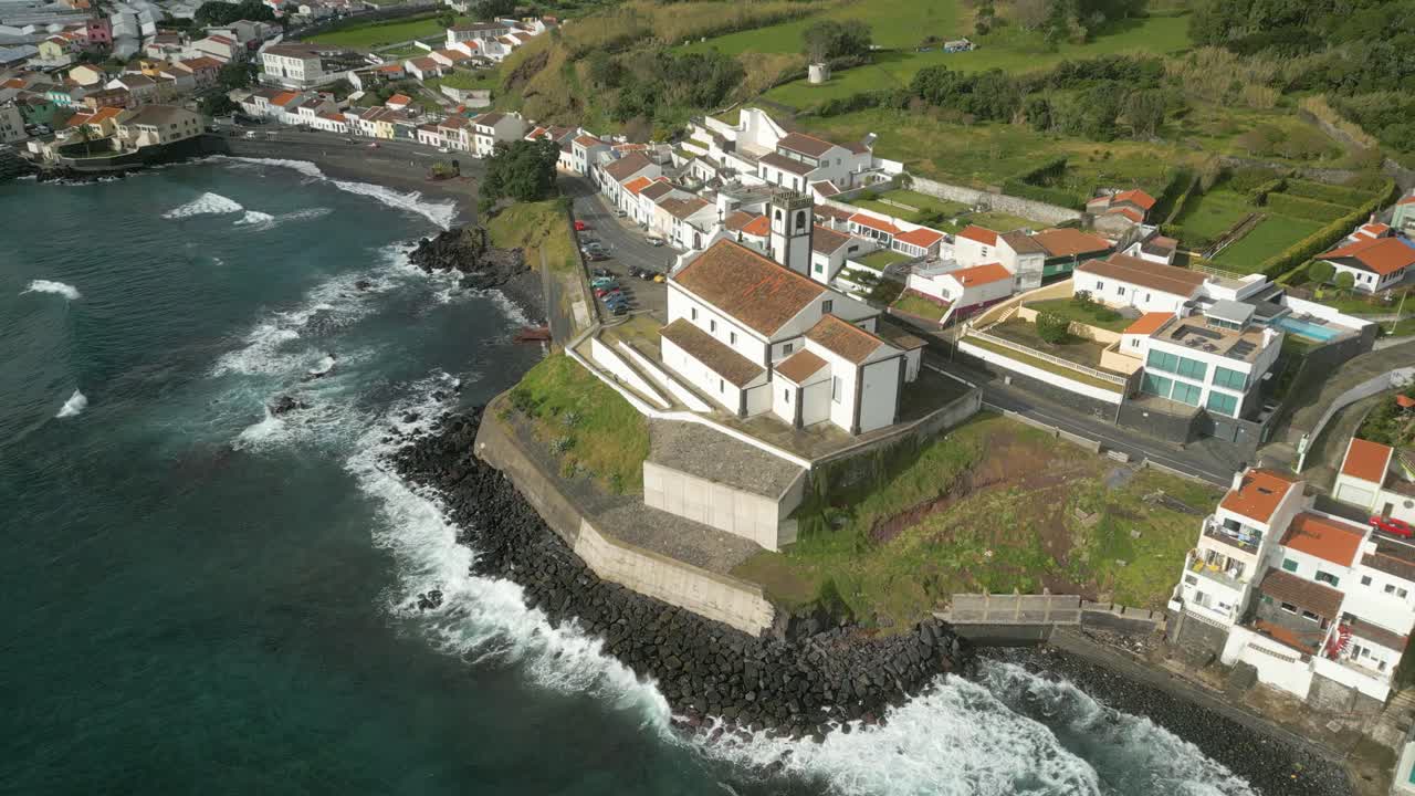 High angle aerial over São Roque Church on rocky coastline, São Miguel