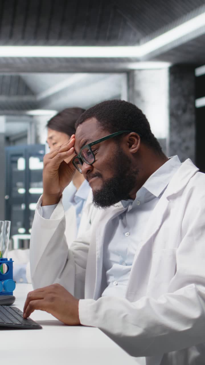 Vertical video Scientist uses computer for DNA data analysis in laboratory, doing brainstorming