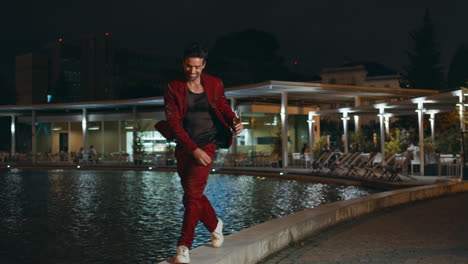 trendy hipster enjoy night party walking at poolside. happy guy relaxing in club