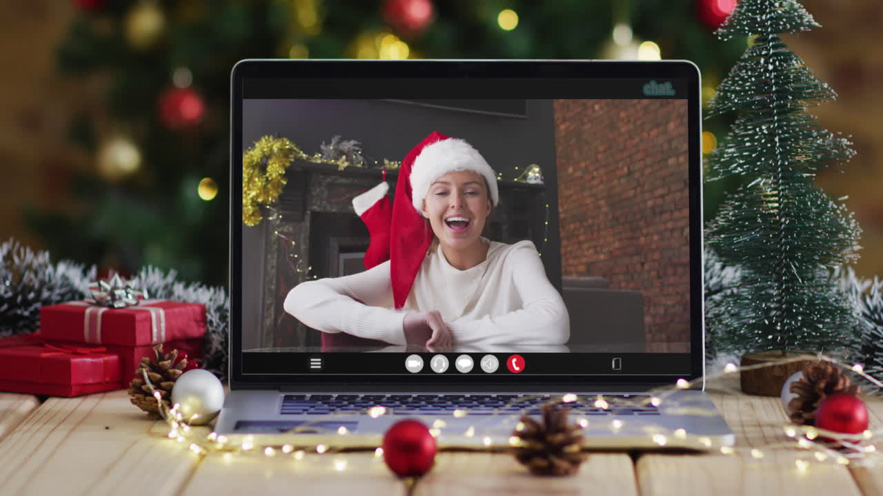 mujer caucásica feliz en videollamada en computadora portátil, con decoraciones de navidad y árbol