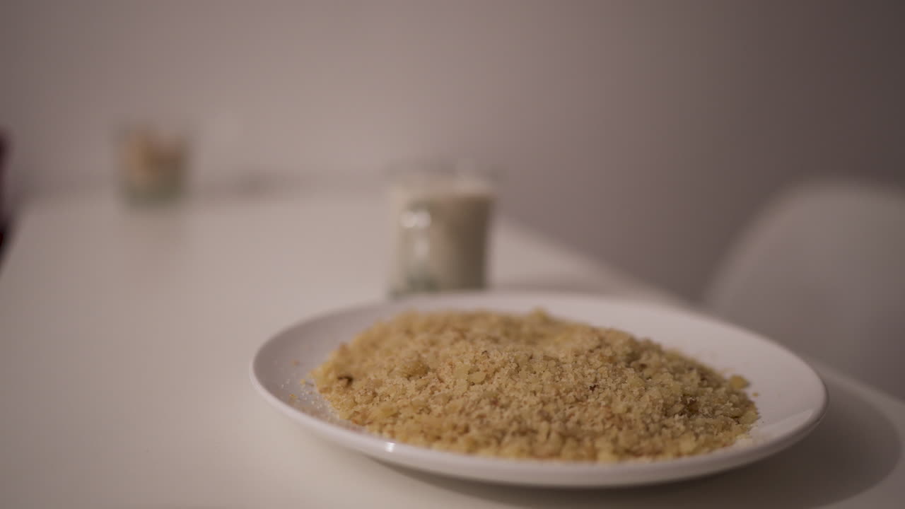 Traditional reviro dish sits on a clean white table alongside a glass of milk, evoking a simple rural breakfast atmosphere in soft focus, captured in a still slow motion scene with side angle.