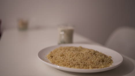 traditional reviro dish sits on a clean white table alongside a glass of milk, evoking a simple rural breakfast atmosphere in soft focus, captured in a still slow motion scene with side angle.