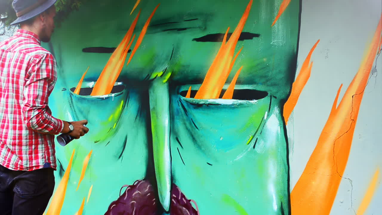Sanatçı, bir çit üzerine grafiti çiziyor. Soyut çizim.