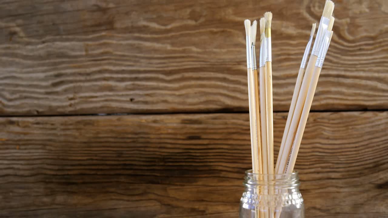 Divers pinceaux sur une table en bois