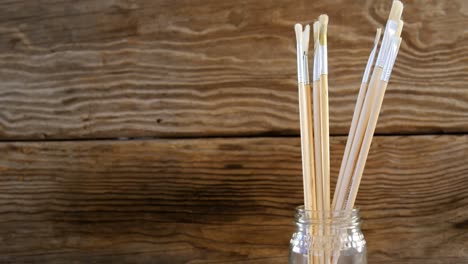 Various-paint-brushes-on-wooden-table