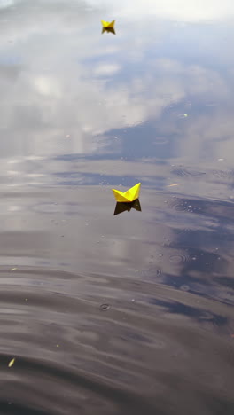 Paper boat sailing along river. Small paper boat is flowing along river. Vertical video