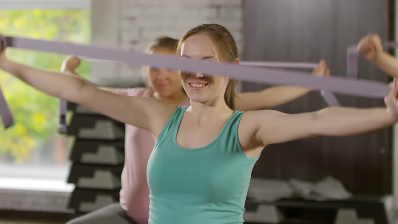 mujer embarazada sonriendo en clase de fitness