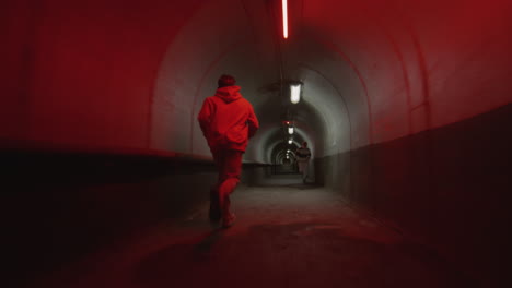 two parkour athletes running in dark tunnel