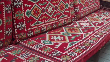 red couch with traditional geometric pattern cushions