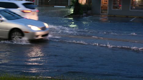 cars driving thur water on road
