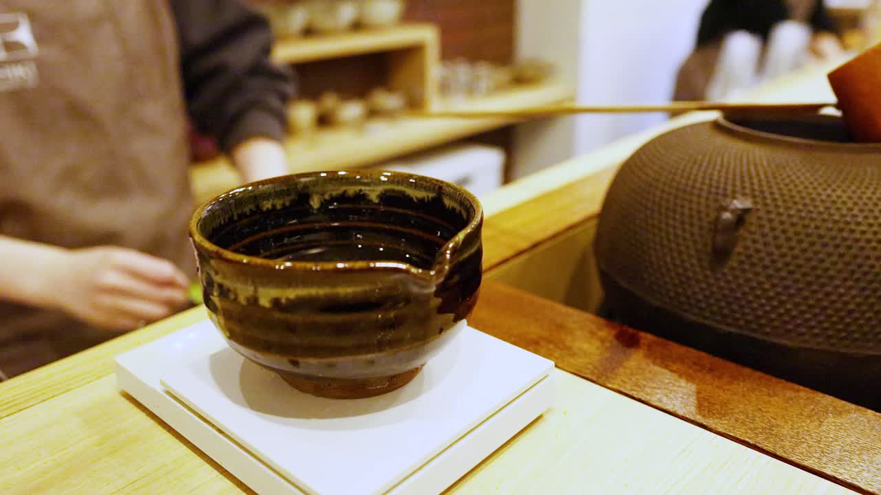 茶道中の陶器の茶碗と鉄瓶の接写。