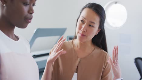 two diverse businesswoman working and talking in office