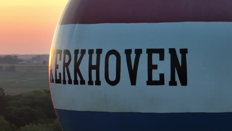 aerial view of kerkhoven water tower in minnesota at golden hour with sun flare