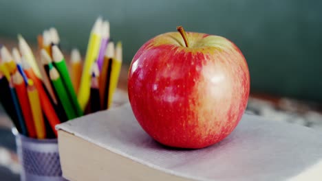 manzana en un libro con lápiz de color en la mesa