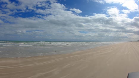 pov de un vehículo de conducción en la playa en la costa nacional de la isla del padre norte cerca de corpus christi texas usa en un día parcialmente nublado con marea baja
