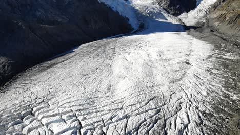 sobrevuelo aéreo sobre el glaciar morteratsch en engadin, suiza al amanecer con vistas a las grietas y piz palu