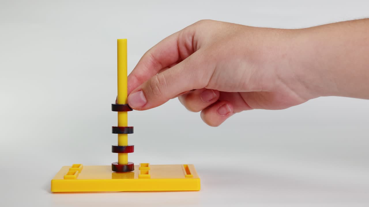 Hands interact with magnetic rings on a stand, demonstrating attraction and repulsion in a controlled environment