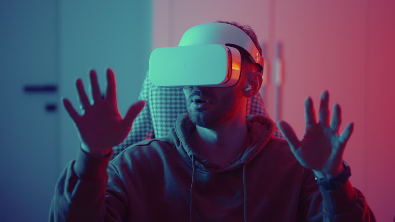 Cyber gamer in VR glasses plays virtual reality game in neon futuristic space. Gaming concept. Young handsome man looks around and shooting from virtual blaster gun. High quality 4k footage
