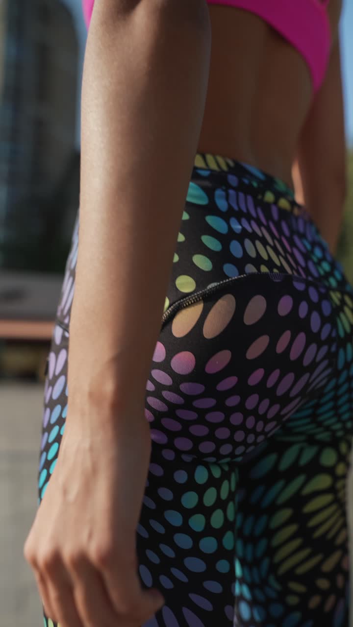 mujer estirándose en ropa deportiva colorida